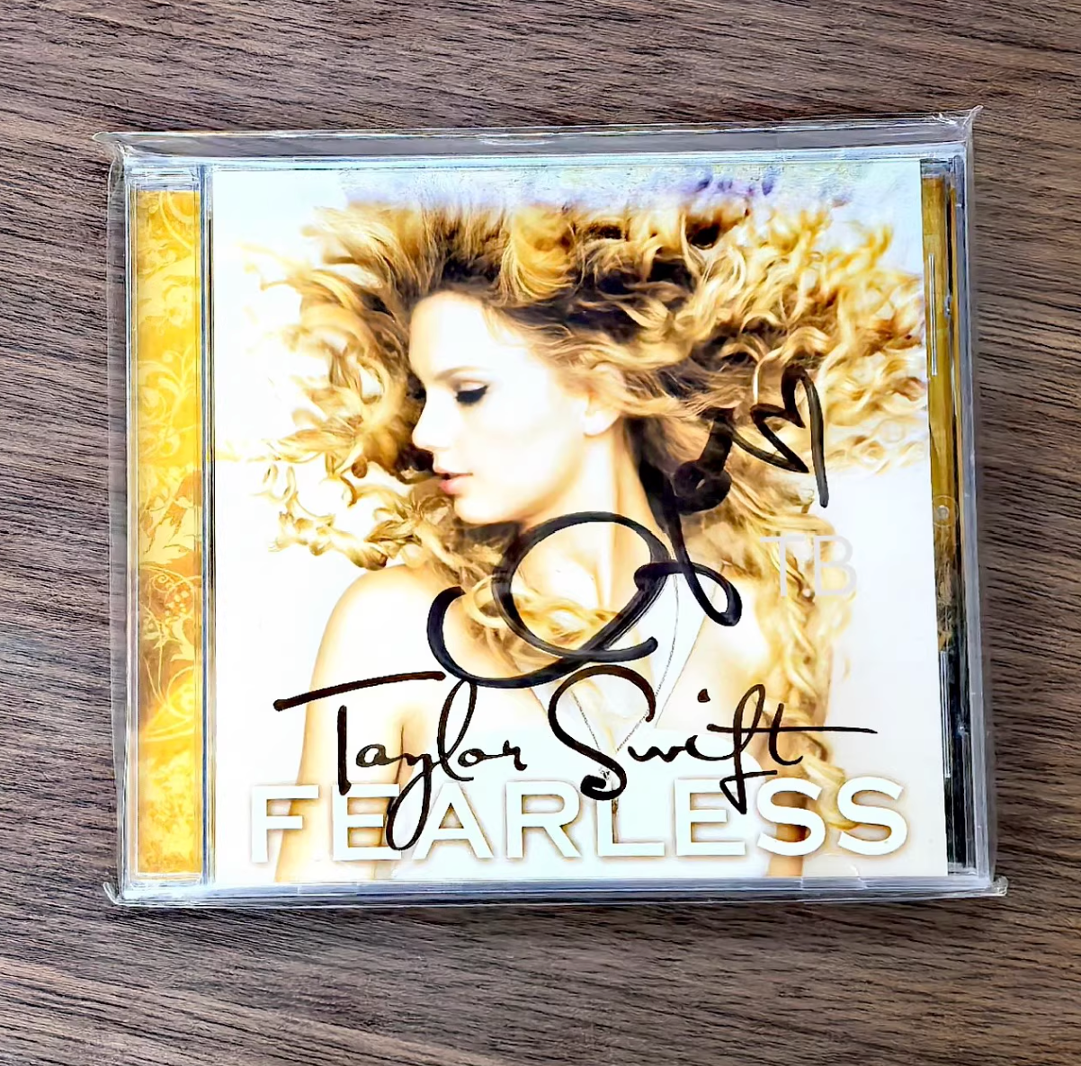Taylor Swift – Fearless (Original Signed CD, Rare Early Autograph)   Original signed CD of *Fearless*, featuring Taylor Swift’s rare early autograph with bold heart motif. Authentic signature in excellent collectible condition. Highly sought-after item.